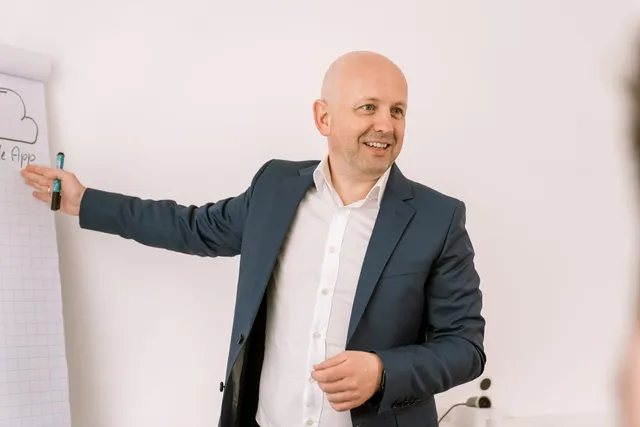 André Krämer erklärt lächelnd eine Skizze am Flipchart