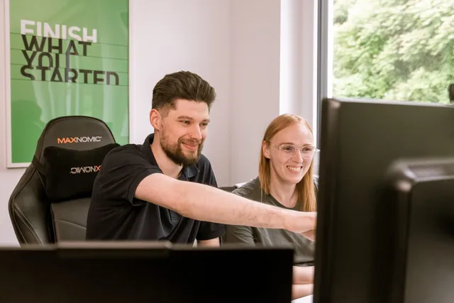 Drei Entwickler arbeiten gemeinsam am Bildschirm