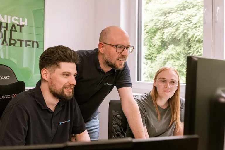 Quality-Bytes-Entwicklerteam gemeinsam am Bildschirm